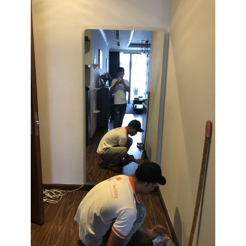 Người thợ đang làm việc bên mảng gương trong hành lang. Ảnh kho Citybuilding; quy cách và địa điểm xác nhận riêng.