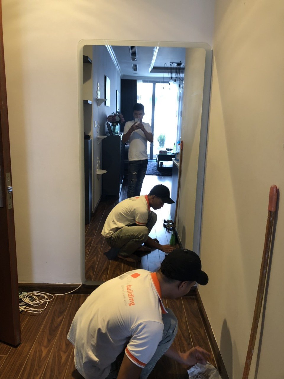 Người thợ đang làm việc bên mảng gương trong hành lang