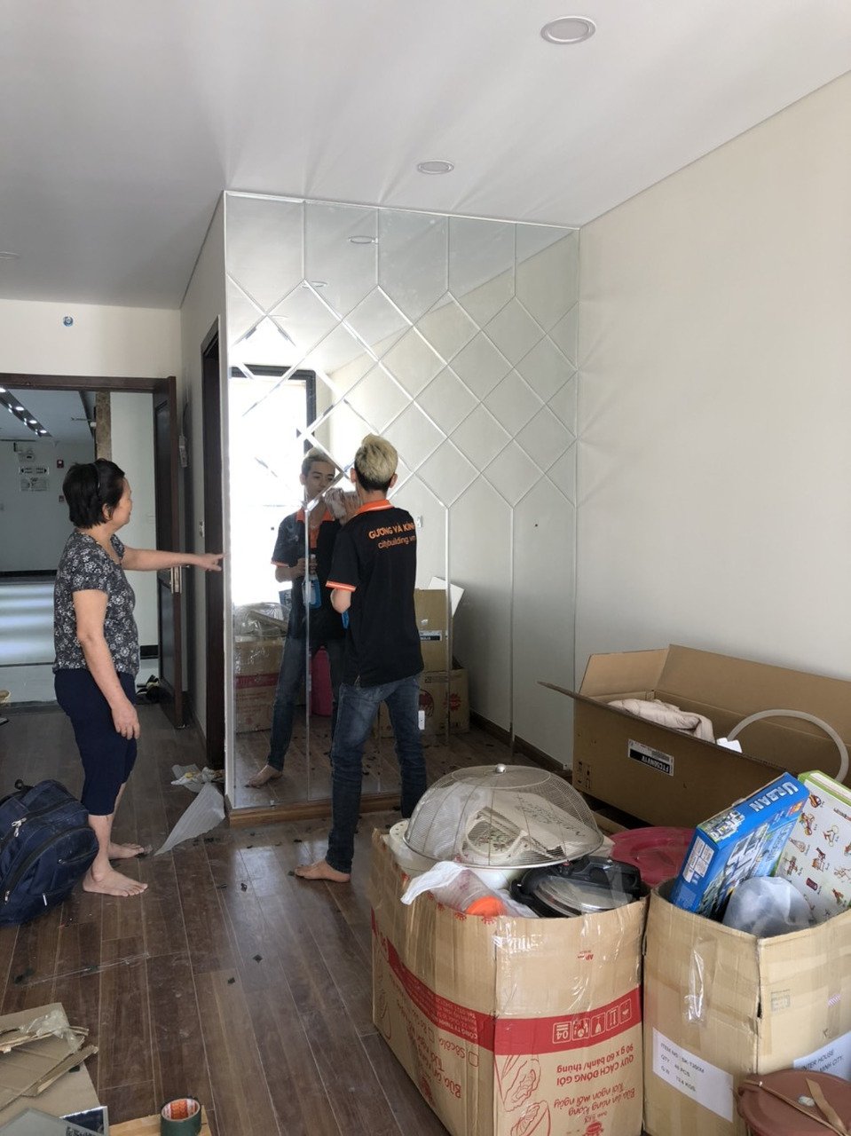 Người thợ bên mảng gương ghép trong phòng đang hoàn thiện