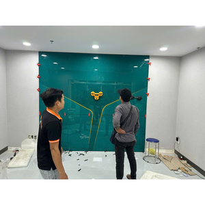 Hai người đứng trước mảng kính tông xanh với kẹp ở mép và dụng cụ hút kính.