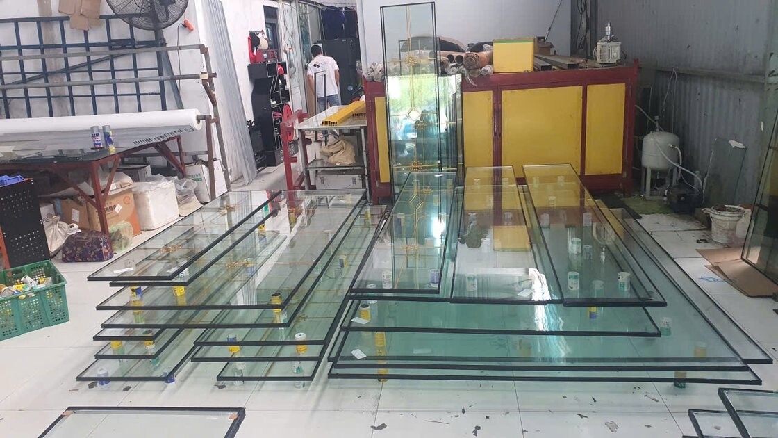 Các tấm kính được xếp ngang thành nhiều tầng trên giá trong xưởng