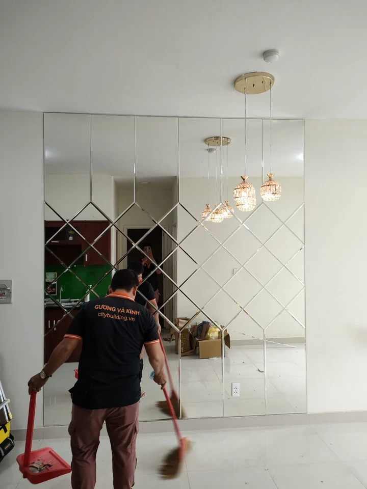 Nhân viên Citybuilding quét dọn khu vực trước mảng gương ghép hình thoi.